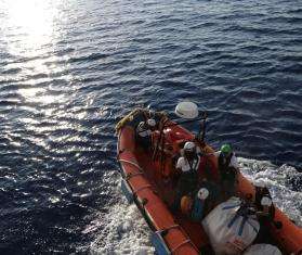 MSF search and rescue teams on an orange rescue boat respond to a migrant ship in distress in the Mediterranean sea 