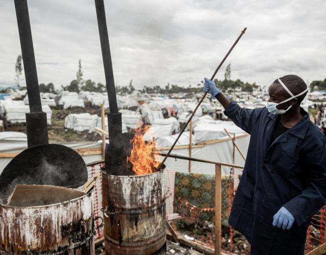 An internally displaced person burns items infected by cholera in a camp in Democratic Republic of Congo.