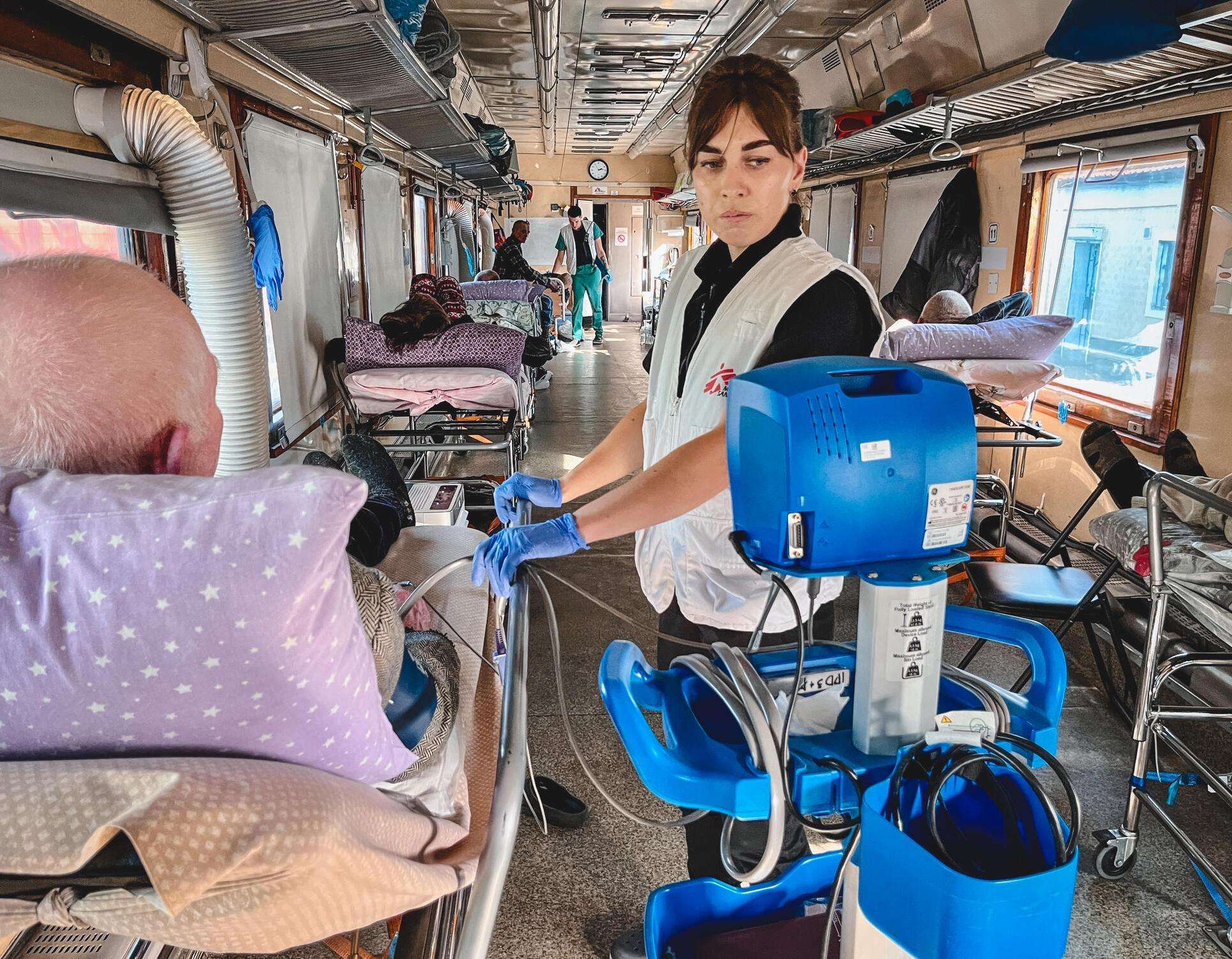 An MSF team member checks the blood pressure of a patient on the MSF medical evacuation train in Ukraine