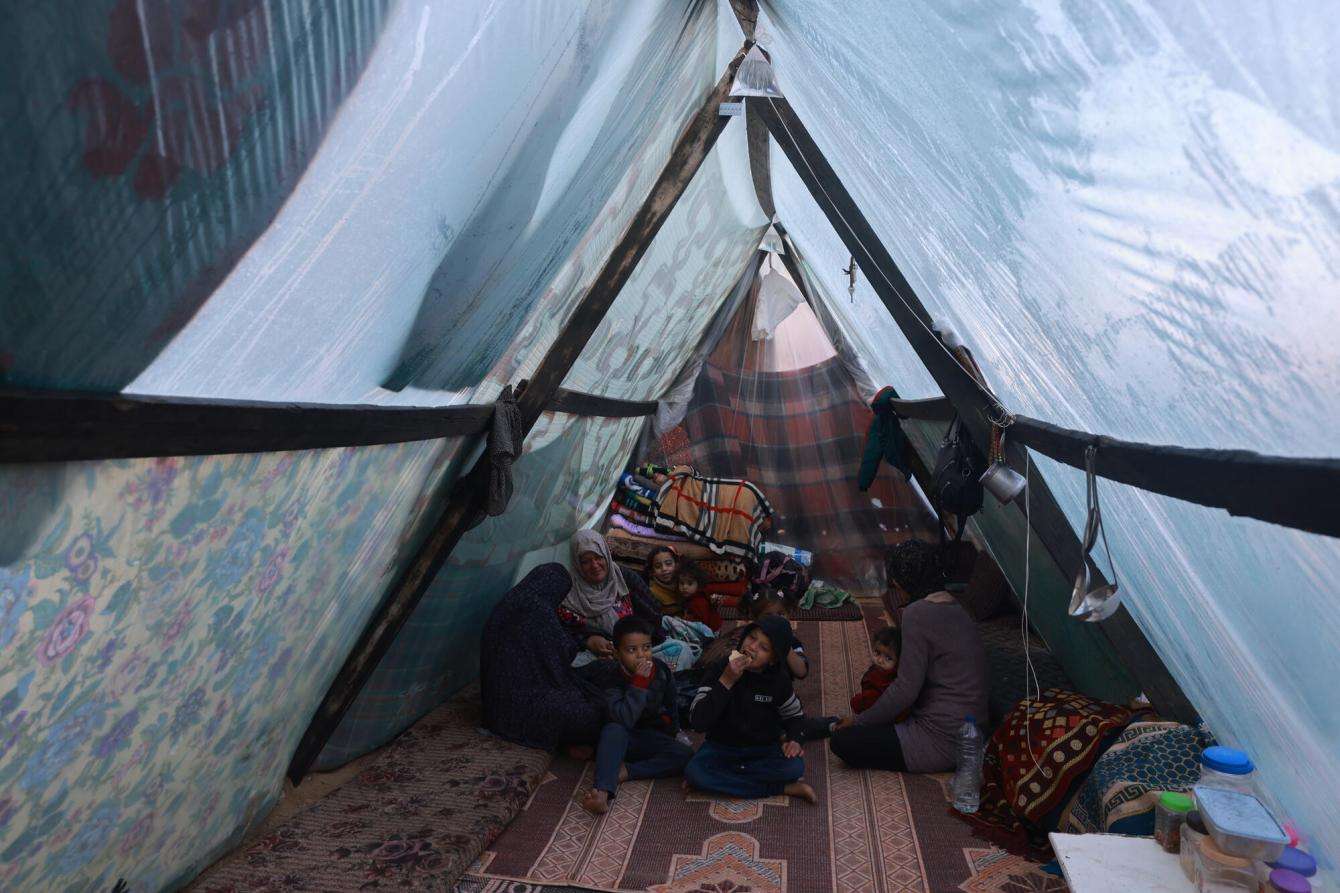 A displaced Palestinian family inside their tent in the southern Gaza town of Rafah’s Al-Shaboura neighborhood.