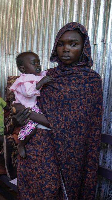 A mother holds her child at MSF's clinic in Zamzam camp in Sudan.