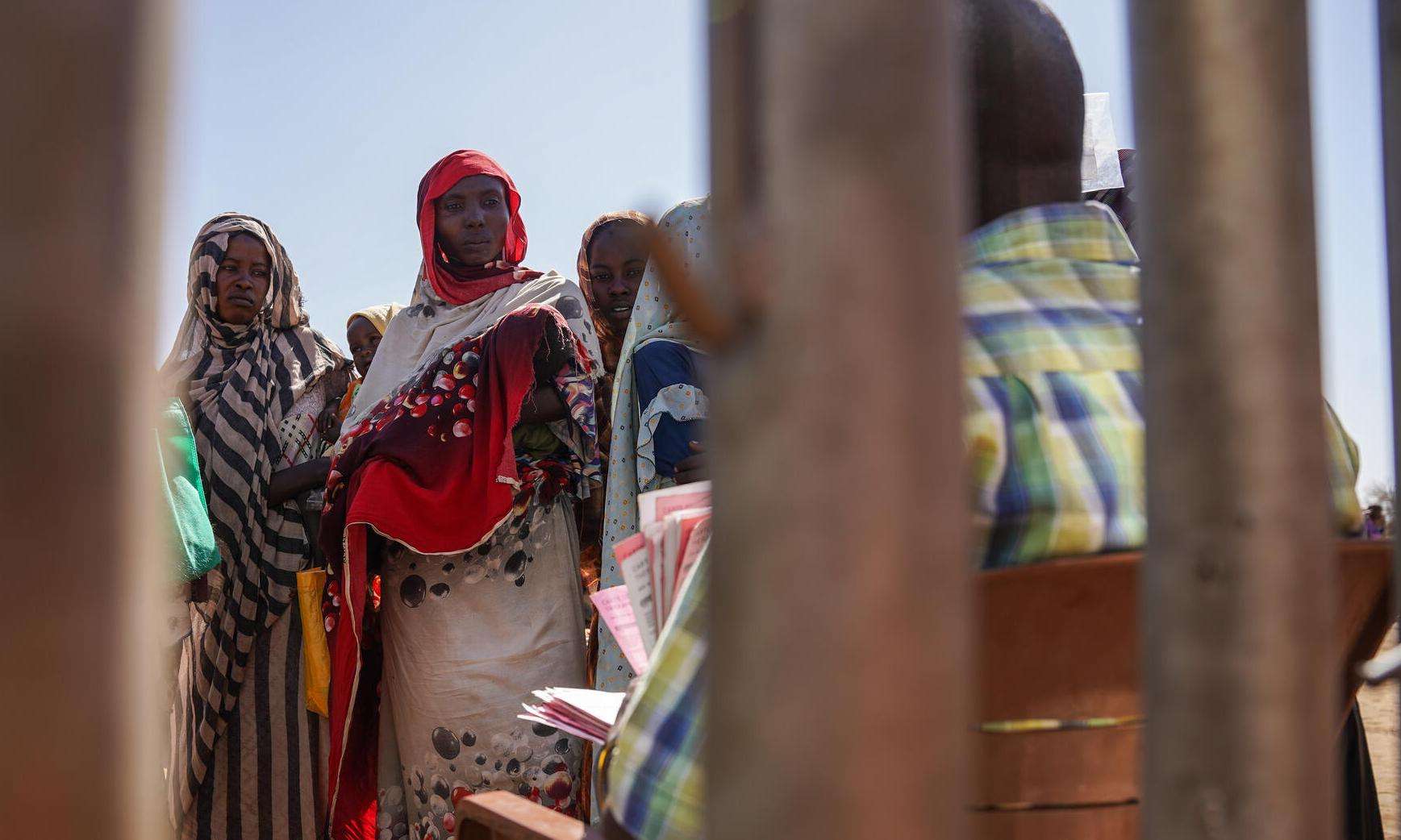 A woman waits in line at a feeding center in Zamzam camp, Sudan. 