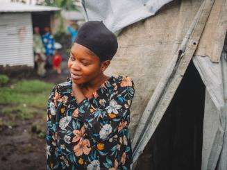 A young woman in front of her makeshift tent in Kanyaruchinya camp for displaced people in DR Congo.