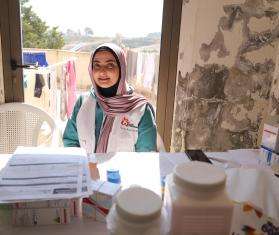 An MSF staff member through the window of a shelter for IDPs in Saida, South Lebanon