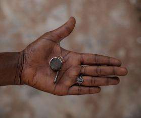 An open hand holding a whistle for protection from sexual violence in Nigeria.