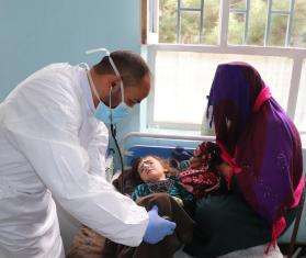 An MSF doctor, Mohammad Qahir Poya checks the vital signs of three-year-old Zainat who was admitted to the measles in the measles isolation ward at Mazar-i-Sharif Regional Hospital, supported by MSF in Afghanistan.