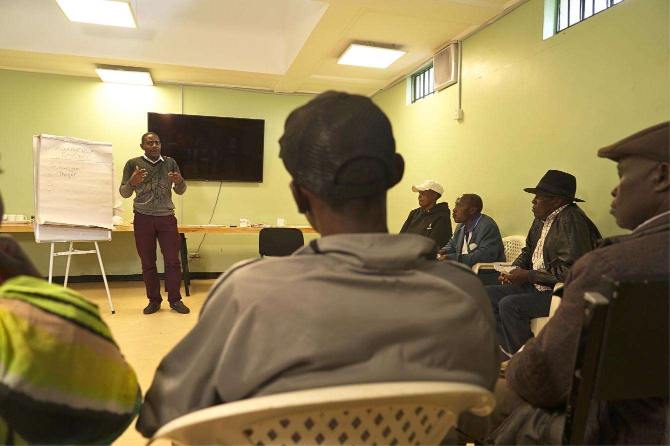 Clement Kagai, a counselor, speaks to patient supporters during a family therapy session, for psychosocial support in Karuri medically assisted therapy (MAT) clinic in Kiambu, Kenya.