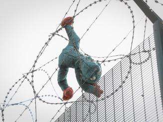 A stuffed animal caught in a barbed wire fence in Calais. 