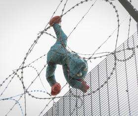 A stuffed animal caught in a barbed wire fence in Calais. 