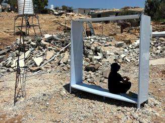 A Palestinian teenager finds shelter from the sun after his home was demolished without warning in Umm al Kheir, Masafer Yatta, West Bank.