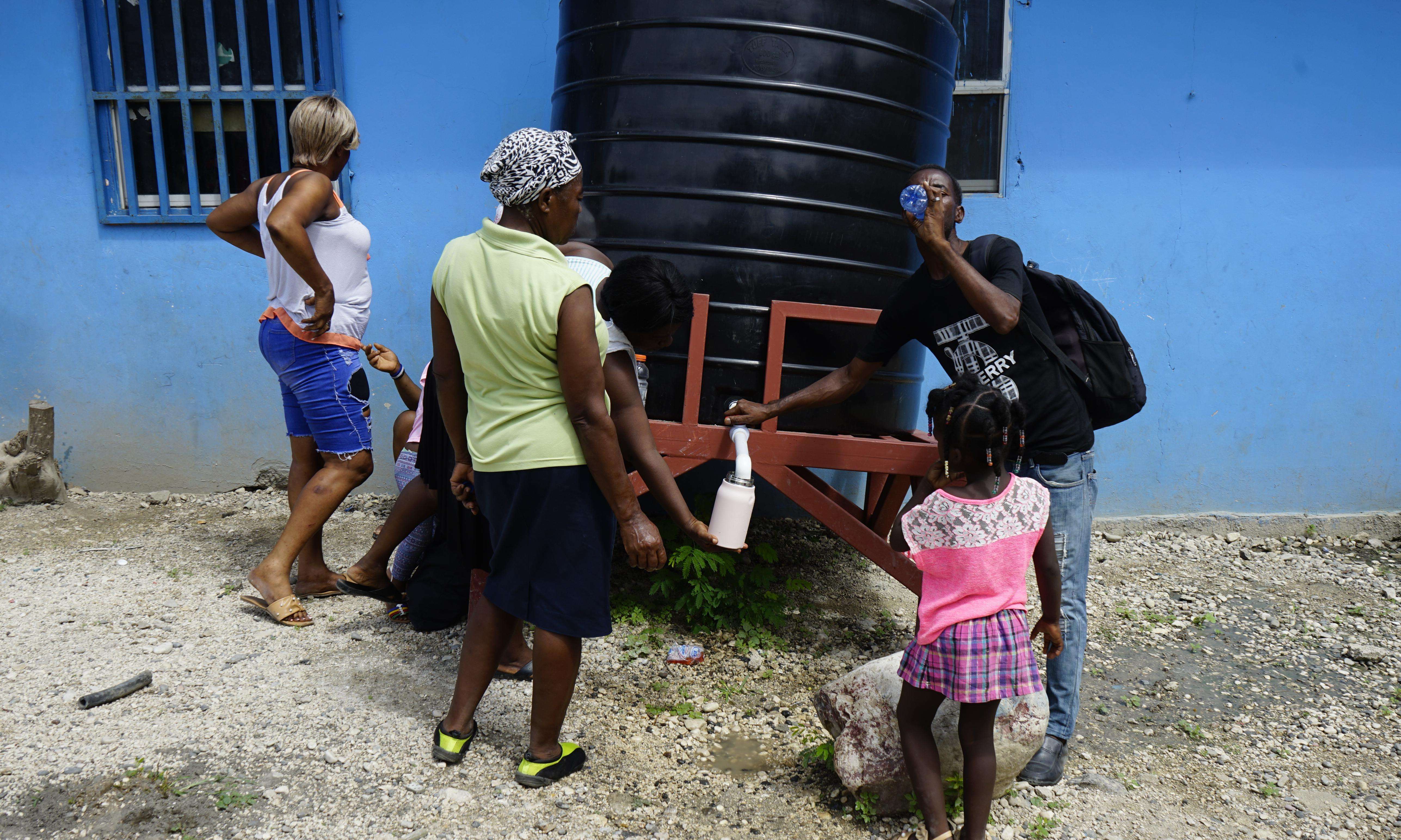 Displaced Haitians collect water.