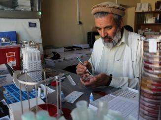 Dr Wardak Abdul Qayoum assists the expat microbiologist in supervising the team and carrying out isolation, identification and sensitivity testing of the 3000 bacterial strains expected. He uses a plastic loop to take a colony of bacteria from the culture plate.