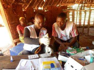 Lab technicians, who are part of a mobile HAT Team in the Democratic Republic of Congo, execute the second step of a test for sleeping sickness.  