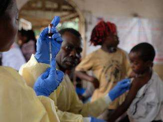 A health worker from the Congolese Ministry of Health prepares to administer a measles vaccine.