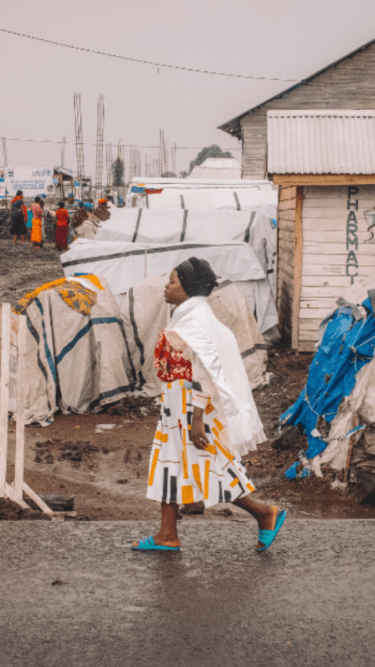 Francine, 24, from Kiwanja in Rutshuru territory, walks through the Kanyaruchinya site for displaced people where she lives, north of the city of Goma, North Kivu, Democratic Republic of Congo, 2 January 2024.